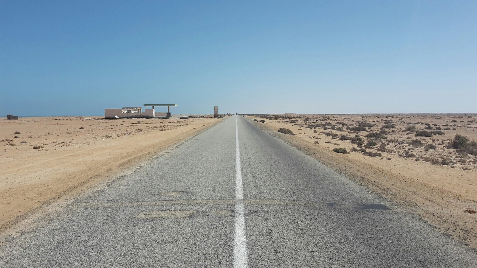 an empty road in the middle of the desert