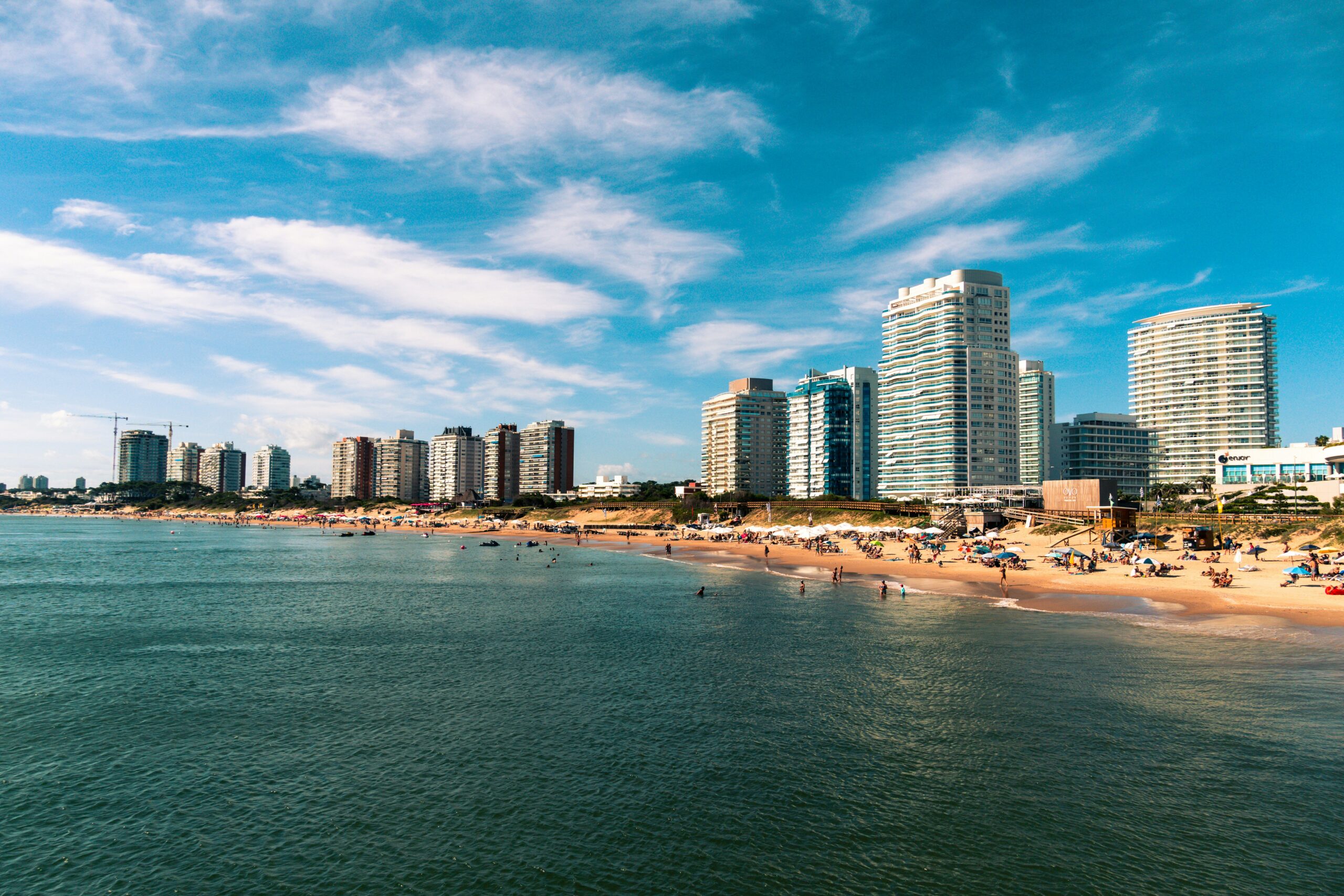 high rise buildings near sea under blue sky and white clouds during daytime