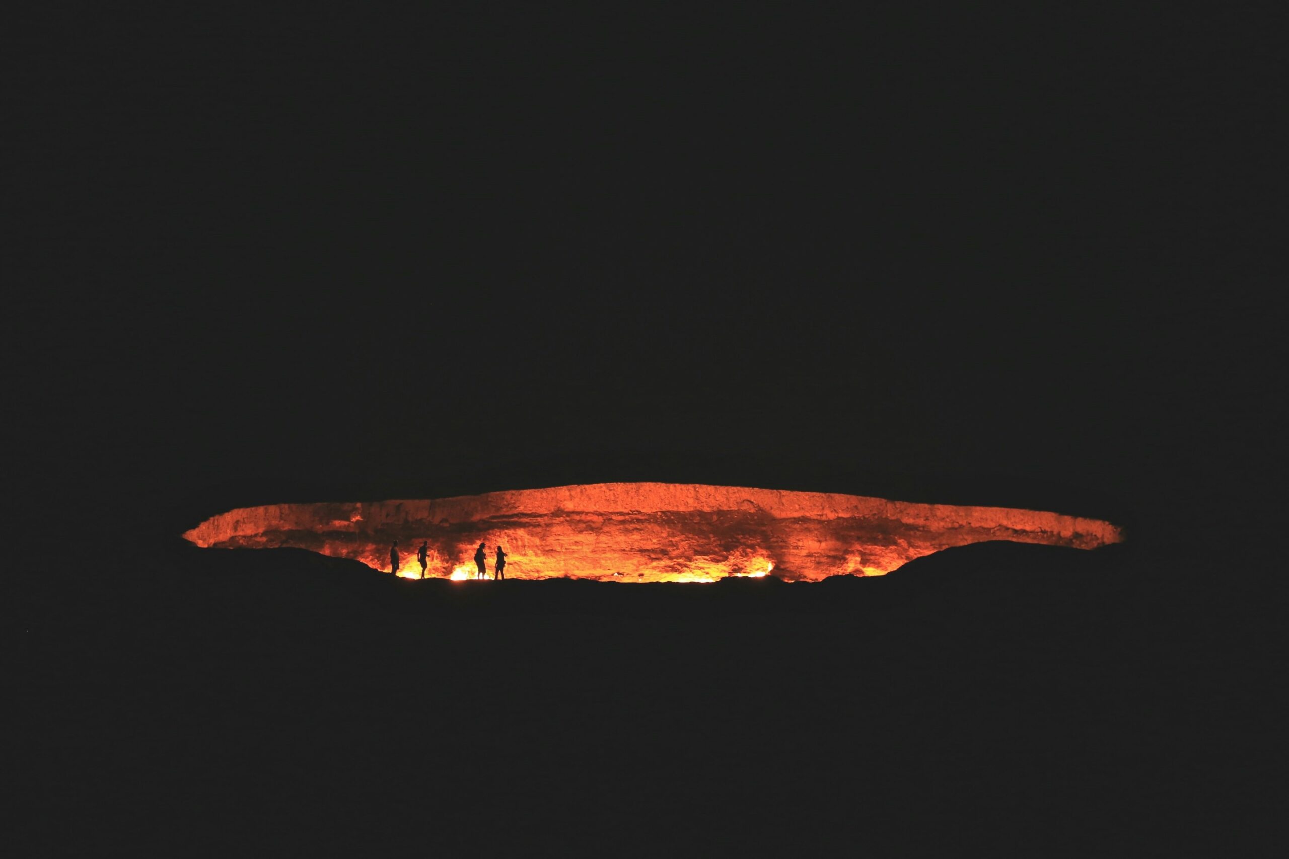 photography of people near cave at night time