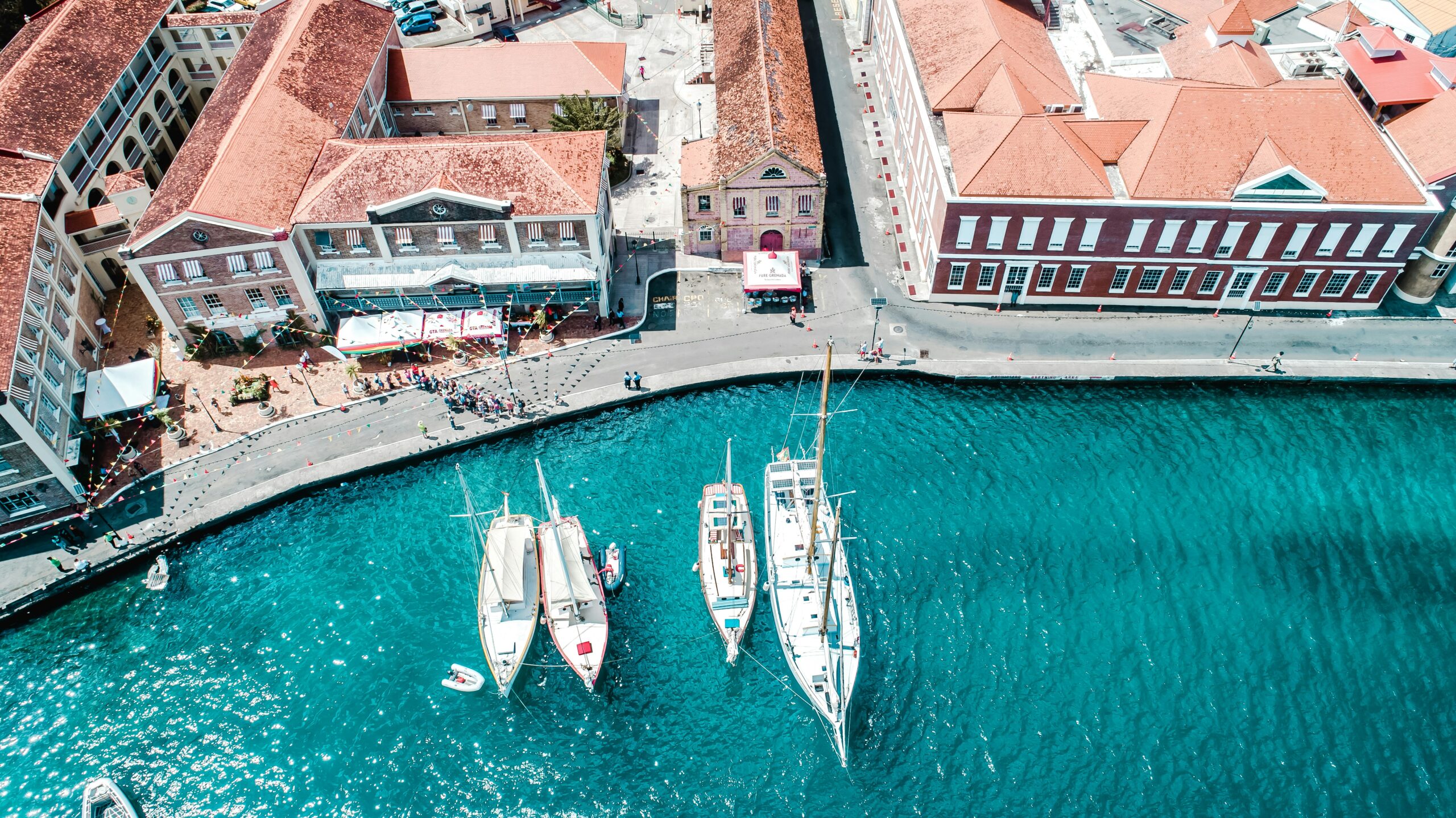 white and blue boat on water near brown concrete building during daytime