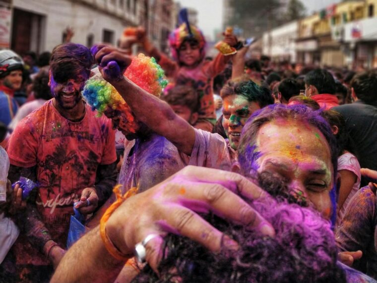 Colorful celebration of Holi Festival in Gorakhpur, India with joyful crowd covered in powders.