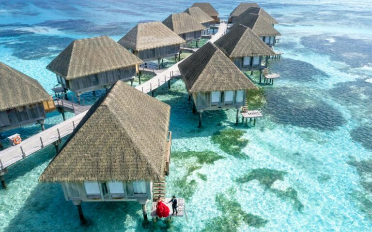 Stunning aerial view of overwater bungalows in Fuvahmulah, Maldives, with crystal clear waters.