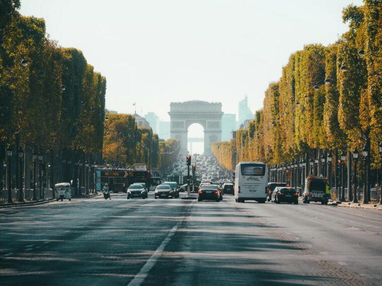 View of the Arc de Triomphe down a busy Champs Élysées in Paris, France, during fall.