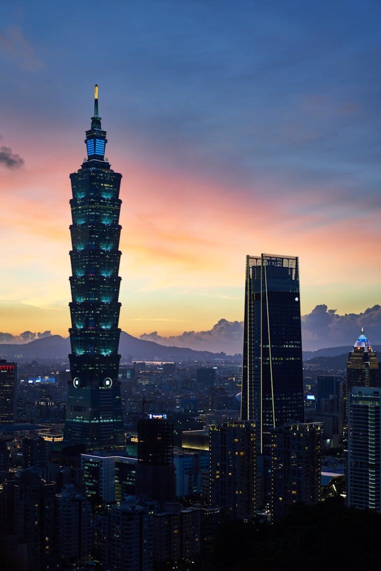 Twilight view of Taipei 101 and city skyline, capturing urban architecture and vibrant sunset.