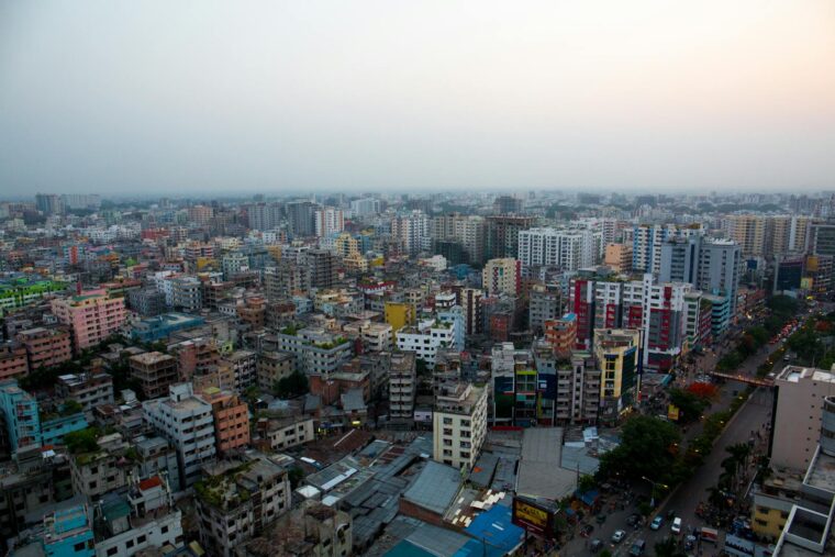 Aerial view of Dhaka's vibrant cityscape with dense urban buildings at twilight.