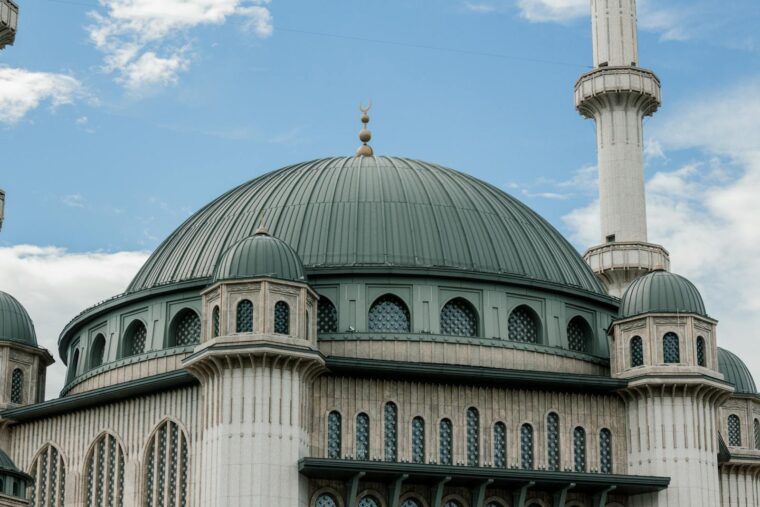 Stunning view of a mosque dome against a clear blue sky, showcasing Islamic architecture.