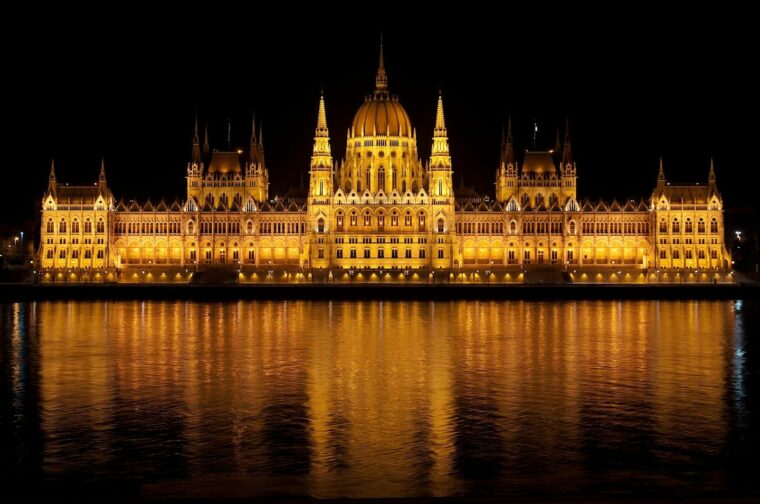 Illuminated view of the Hungarian Parliament Building reflecting in the Danube at night.