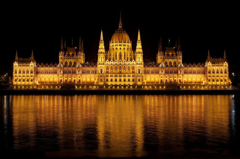 Illuminated view of the Hungarian Parliament Building reflecting in the Danube at night.