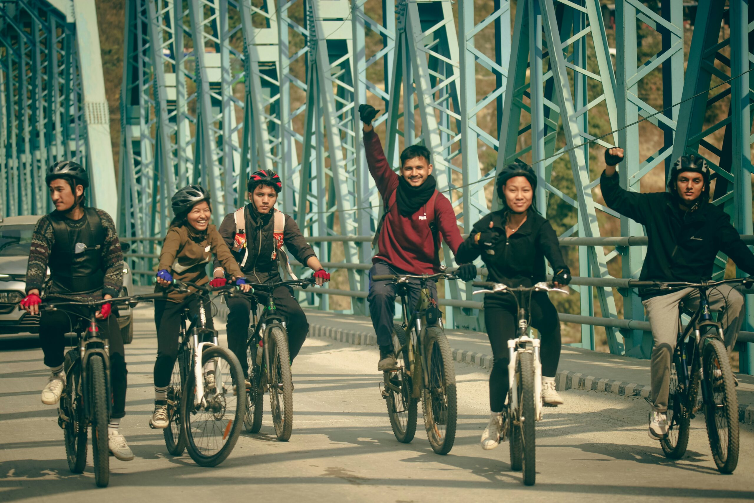 a group of people riding bikes across a bridge