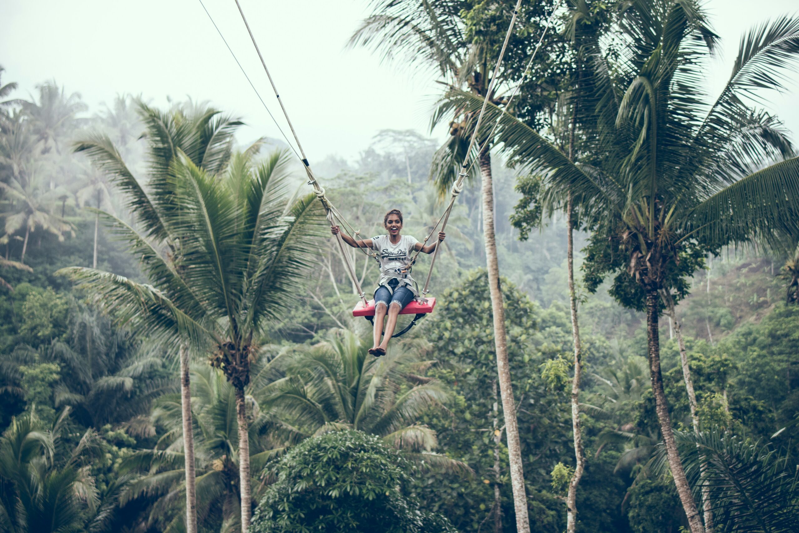 woman using brown rope hammock during daytime