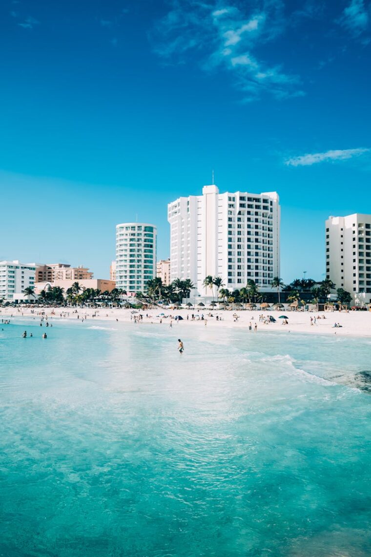 Scenic view of modern hotels along the beachfront in Cancun, Mexico, with clear blue waters.