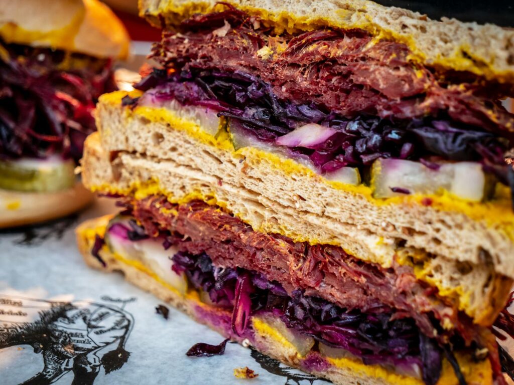 Close-up of a delicious salted beef sandwich with mustard and fresh vegetables.