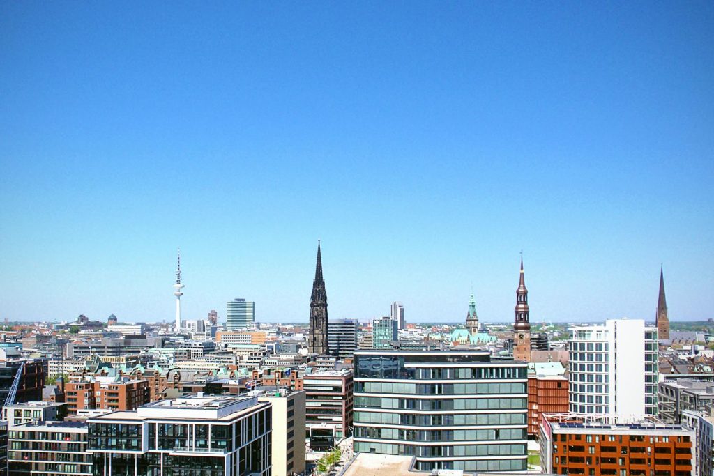 High-rise buildings under clear blue sky in Hamburg cityscape.